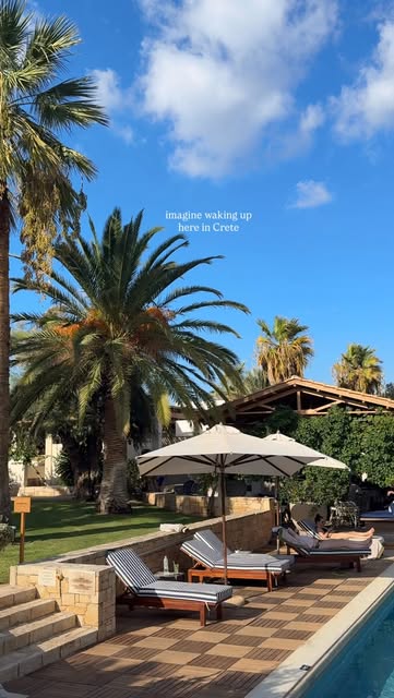 Sun loungers and a palm-lined pool at a resort in Crete